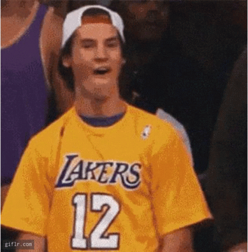 A Man Wearing A Yellow Lakers Jersey With The Number 12 On It . GIF