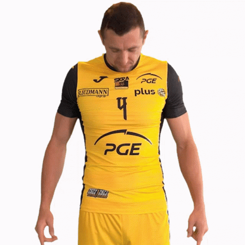 A Man Wearing A Yellow Pge Shirt Stands With His Hands On His Hips GIF