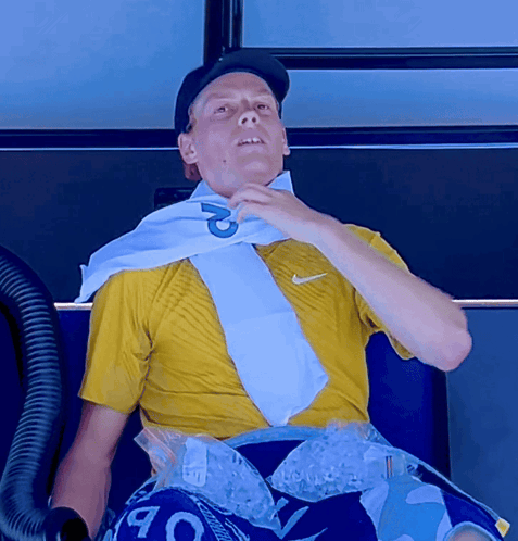a man wearing a yellow shirt and a white scarf with the letter p on it