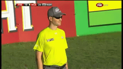A Man Wearing A Yellow Shirt That Says ' Fox Sports ' On It GIF
