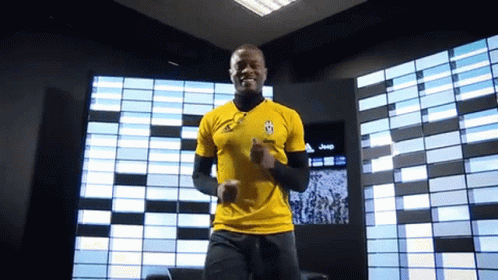 A Man Wearing A Yellow Shirt With A Jeep Logo On It GIF