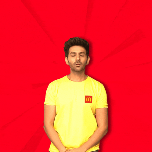 A Man Wearing A Yellow Shirt With A Mcdonald 'S Logo On It Says Let 'S Go Eat GIF