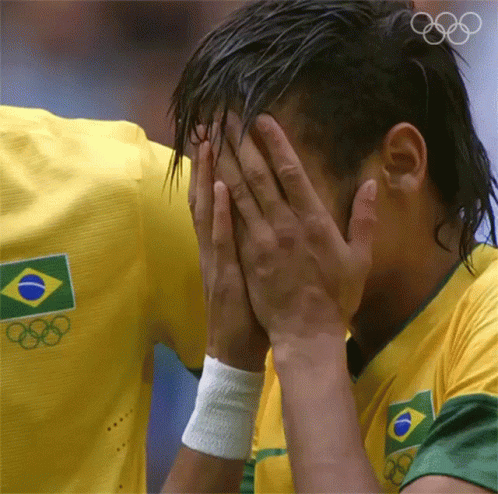 a man wearing a yellow shirt with the olympic rings on it