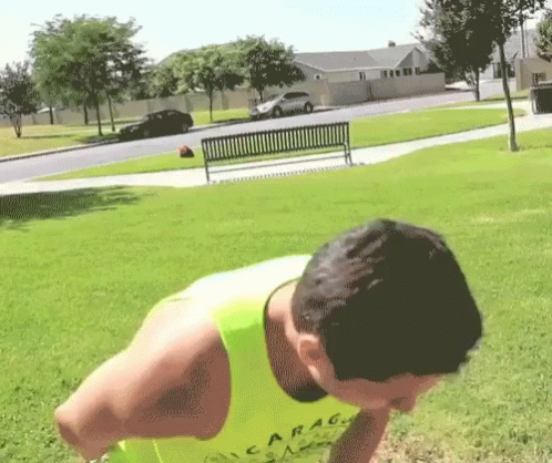 A Man Wearing A Yellow Tank Top That Says Garag On It GIF