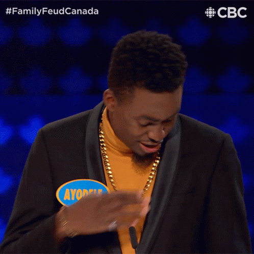 A Man Wearing A Yellow Turtleneck And A Black Suit Has Ayobele Written On A Blue Sticker GIF