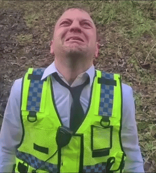 A Man Wearing A Yellow Vest And Tie Looks Up At Something GIF