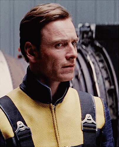 A Man Wearing A Yellow Vest With A Black Collar And Straps GIF