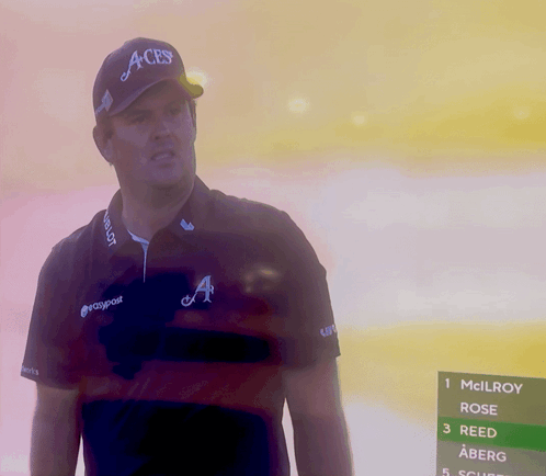 A Man Wearing An Aces Hat Stands In Front Of A Screen GIF
