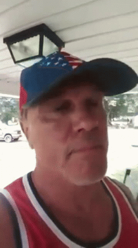 A Man Wearing An American Flag Hat And A Red White And Blue Shirt GIF