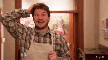 A Man Wearing An Apron And A Plaid Shirt Is Scratching His Head In A Kitchen . GIF