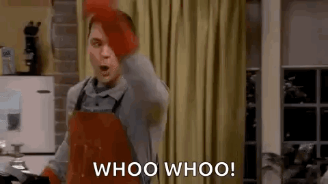 A Man Wearing An Apron And Gloves Is Standing In A Kitchen And Shouting Whoo Whoo . GIF