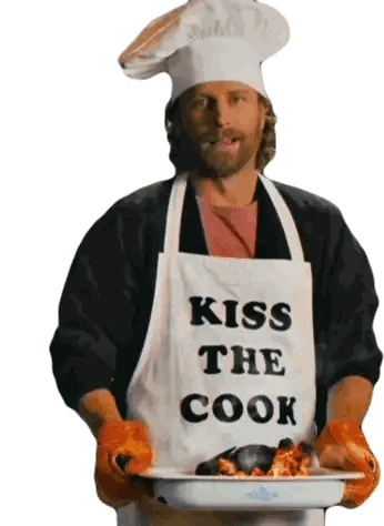 a man wearing an apron that says kiss the cook holds a tray of food