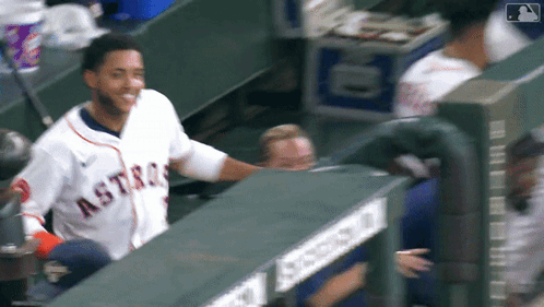 A Man Wearing An Astros Jersey Is Standing In The Dugout GIF
