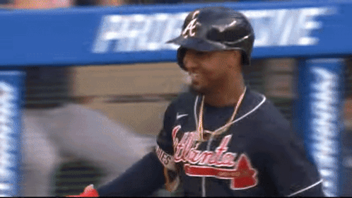 A Man Wearing An Atlanta Braves Jersey And A Helmet GIF