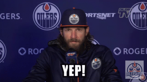 a man wearing an oilers hat says yep in front of a blue wall