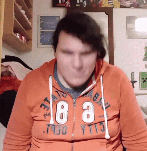A Man Wearing An Orange Hoodie That Says ' T930 Yt13 ' On It GIF