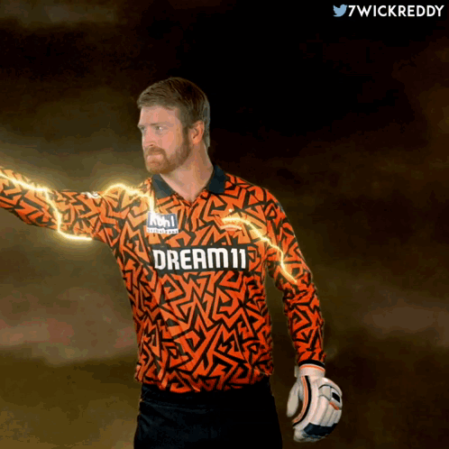 A Man Wearing An Orange Jersey That Says Dream11 On It GIF