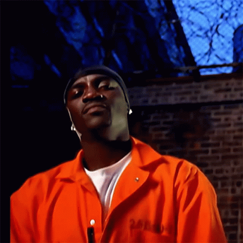 A Man Wearing An Orange Jumpsuit Has The Number 24 On His Chest GIF