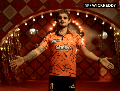 A Man Wearing An Orange Shirt That Says Shree Cement On It GIF