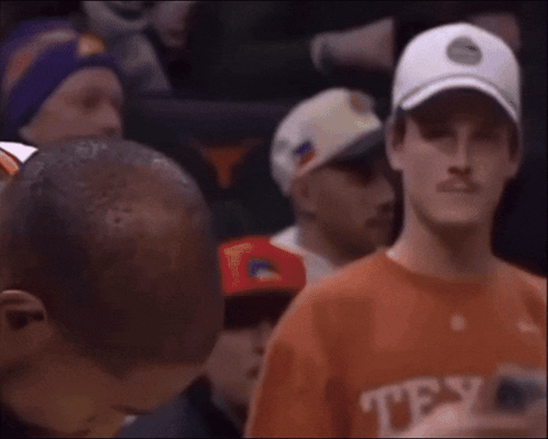 A Man Wearing An Orange Shirt That Says Texas On The Front GIF