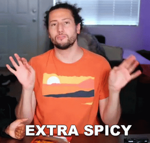 A Man Wearing An Orange Shirt With The Word Extra Spicy On It GIF