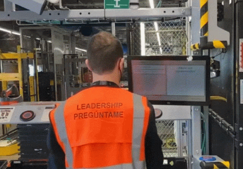a man wearing an orange vest with leadership preguntame on it