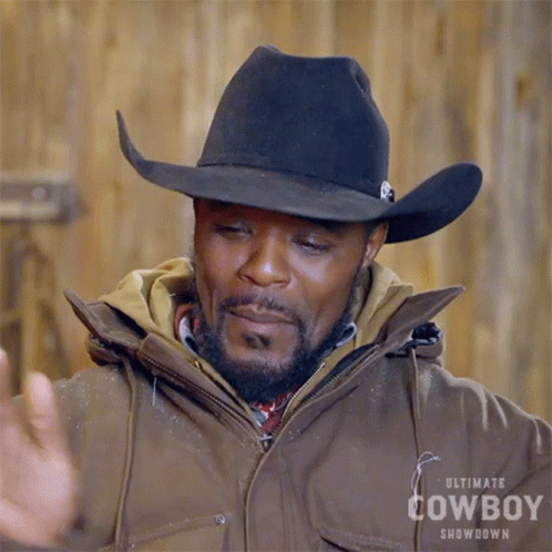 A Man Wearing An Ultimate Cowboy Showdown Jacket And Cowboy Hat GIF