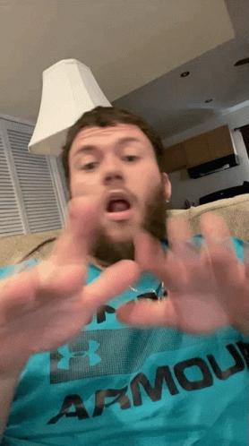 A Man Wearing An Under Armour Shirt Is Making A Funny Face GIF
