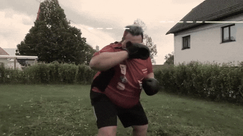 A Man Wearing Boxing Gloves And A Red Shirt That Says ' Team ' On It GIF