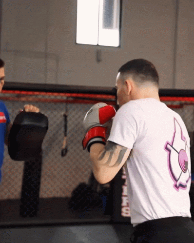 A Man Wearing Boxing Gloves And A Shirt That Says ' Fire ' On The Back Of It GIF