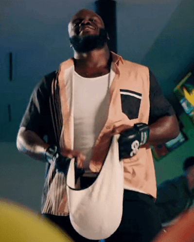 A Man Wearing Boxing Gloves And A Vest With The Letter G On The Front GIF