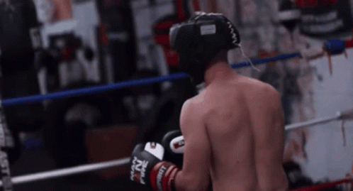 A Man Wearing Boxing Gloves That Say Nz On Them Is Standing In A Boxing Ring GIF