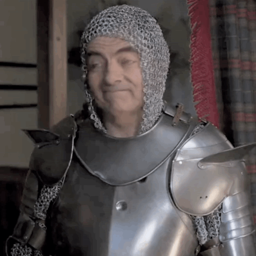 A Man Wearing Chain Mail And Armor Is Smiling GIF