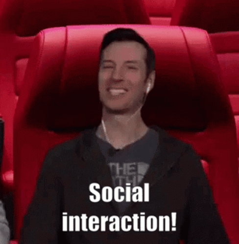 A Man Wearing Ear Buds Is Sitting In A Movie Theater And Says Social Interaction . GIF
