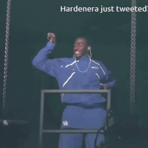 A Man Wearing Ear Buds Stands In Front Of A Screen That Says Hardenera Just Tweeted GIF