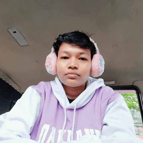 A Man Wearing Ear Warmers And A Purple Shirt That Says Dallas GIF