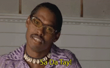 A Man Wearing Glasses , A Necklace And A Purple Shirt Is Saying Sa Da Tay . GIF