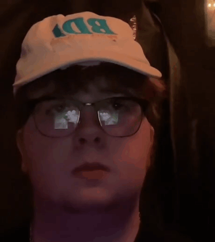 A Man Wearing Glasses And A Bd Hat GIF