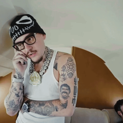 A Man Wearing Glasses And A Beanie With A Skull On It GIF