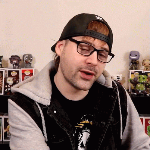 A Man Wearing Glasses And A Black Hat With The Adidas Logo On It GIF