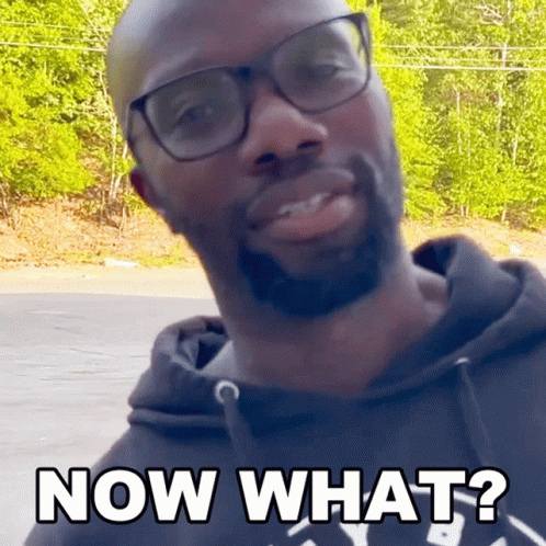 A Man Wearing Glasses And A Black Hoodie Is Asking " Now What " GIF