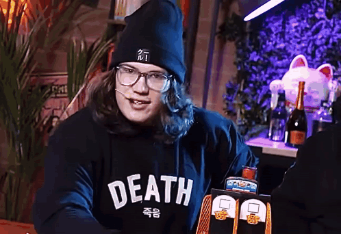 a man wearing glasses and a black hoodie that says death