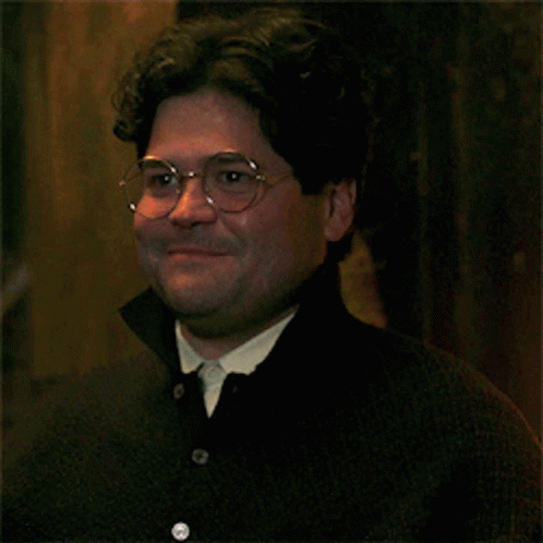 A Man Wearing Glasses And A Black Shirt Smiles For The Camera GIF