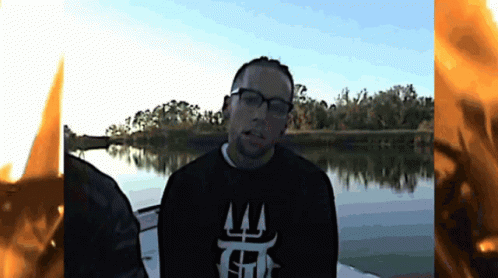 A Man Wearing Glasses And A Black Shirt That Says T On It GIF