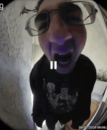 A Man Wearing Glasses And A Black Shirt With A Skull On It GIF