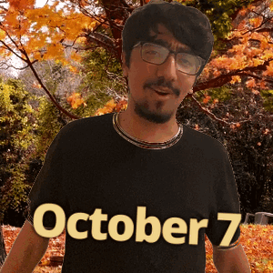 A Man Wearing Glasses And A Black Shirt With October 7 Written On It GIF