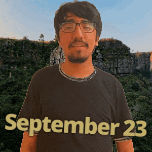 a man wearing glasses and a black shirt with september 23 written on it