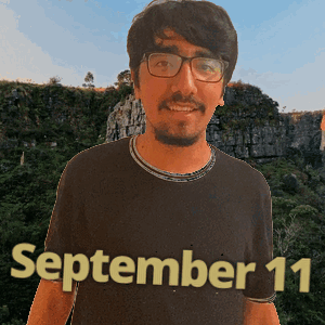 a man wearing glasses and a black shirt with the date september 11 on it