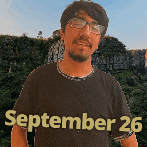 a man wearing glasses and a black shirt with the date september 26 on it