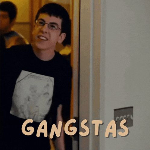 A Man Wearing Glasses And A Black Shirt With The Word Gangsta On It GIF